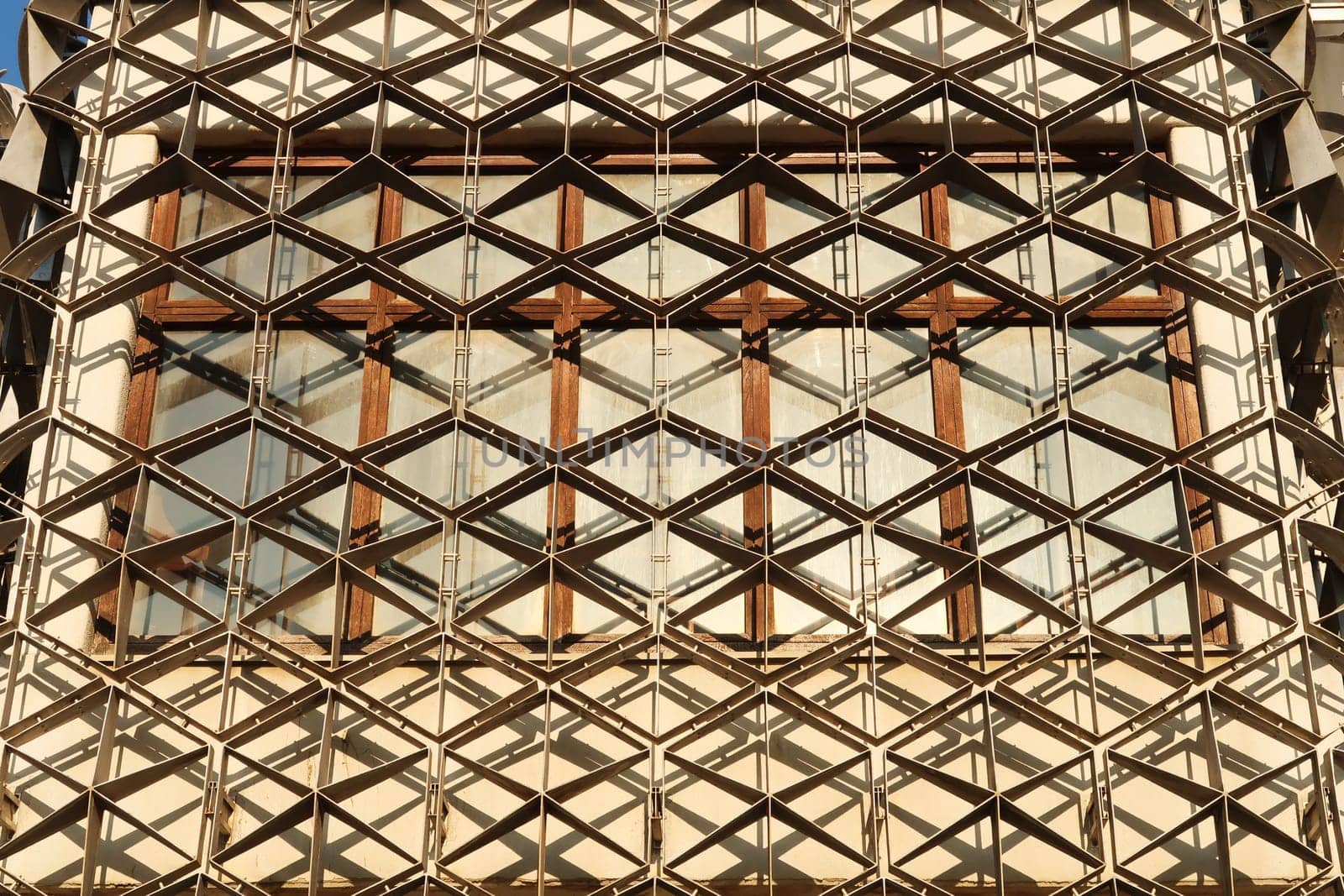 A window of the National University Library of Kosovo, covered by a metal grid, net, an example of socialist, brutalist architecture in the city center of Prishtina, Pristina, Kosovo 2022