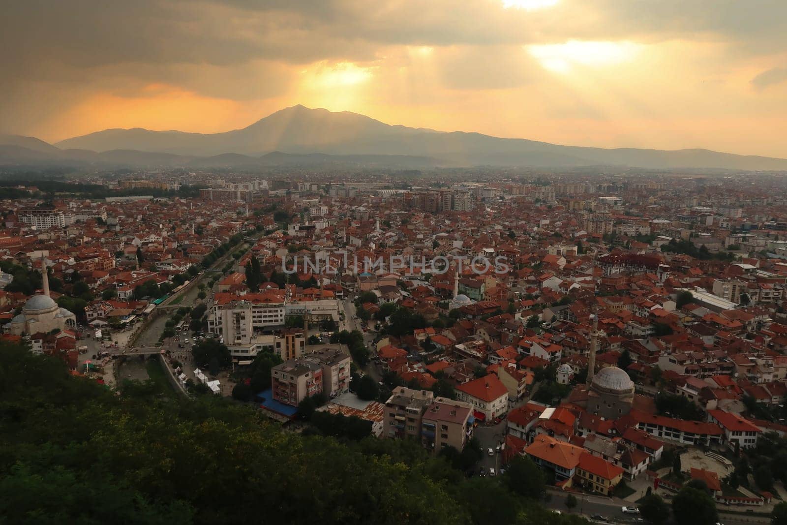 View from the Prizren Fortress onto the old town of Prizren before sunset, golden sunlight is breaking through the clouds, Prizren, Kosovo 2022