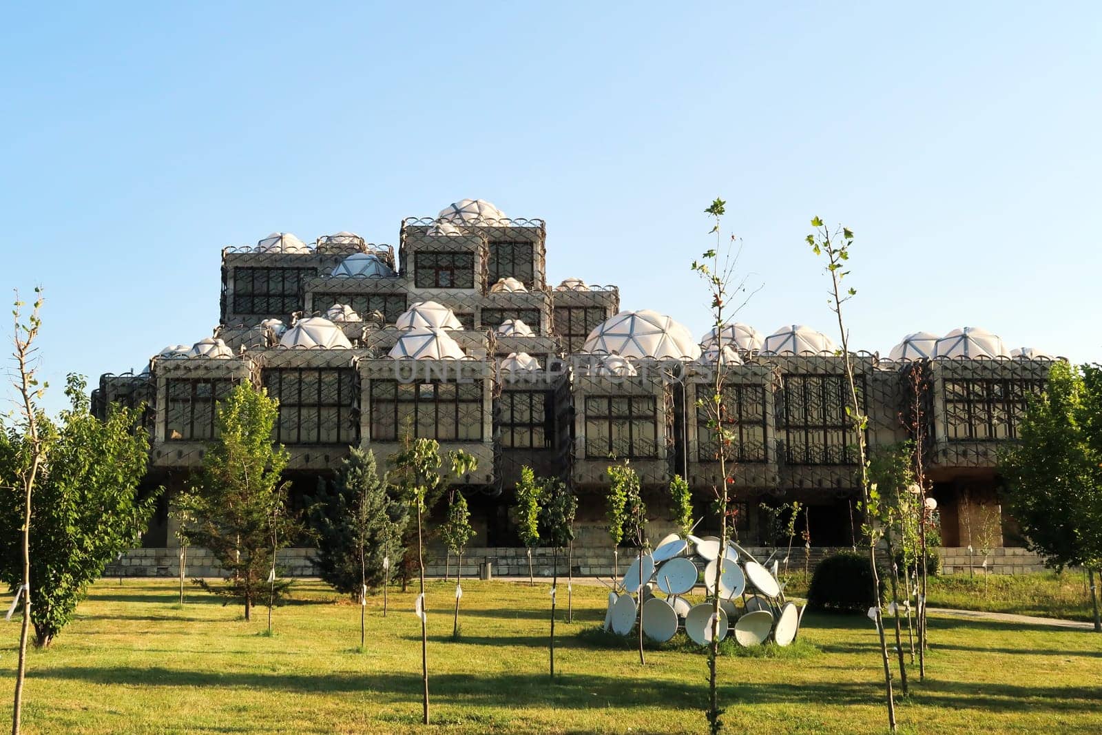 The the National University Library of Kosovo, covered by a metal grid, net, many white domes with geometric pattern on top, an example of socialist, brutalist architecture in the city center of Prishtina, Pristina, Kosovo 2022