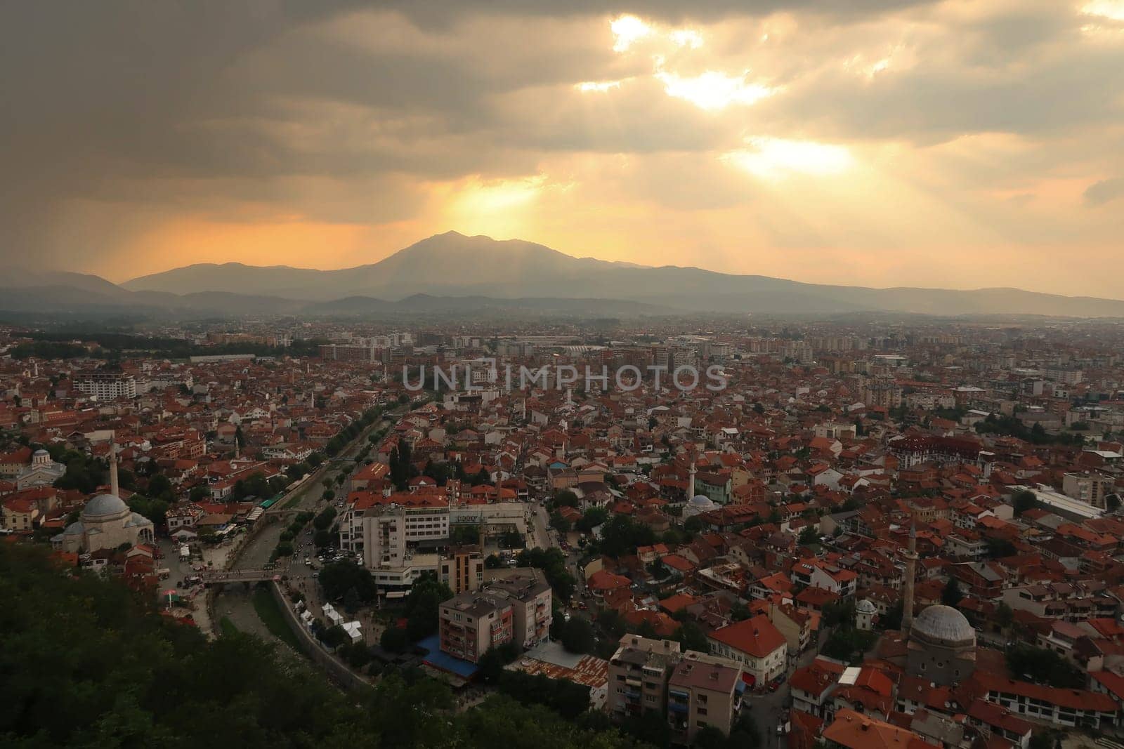 View from the Prizren Fortress onto the old town of Prizren before sunset, golden sunrays are breaking through the clouds, Prizren, Kosovo 2022