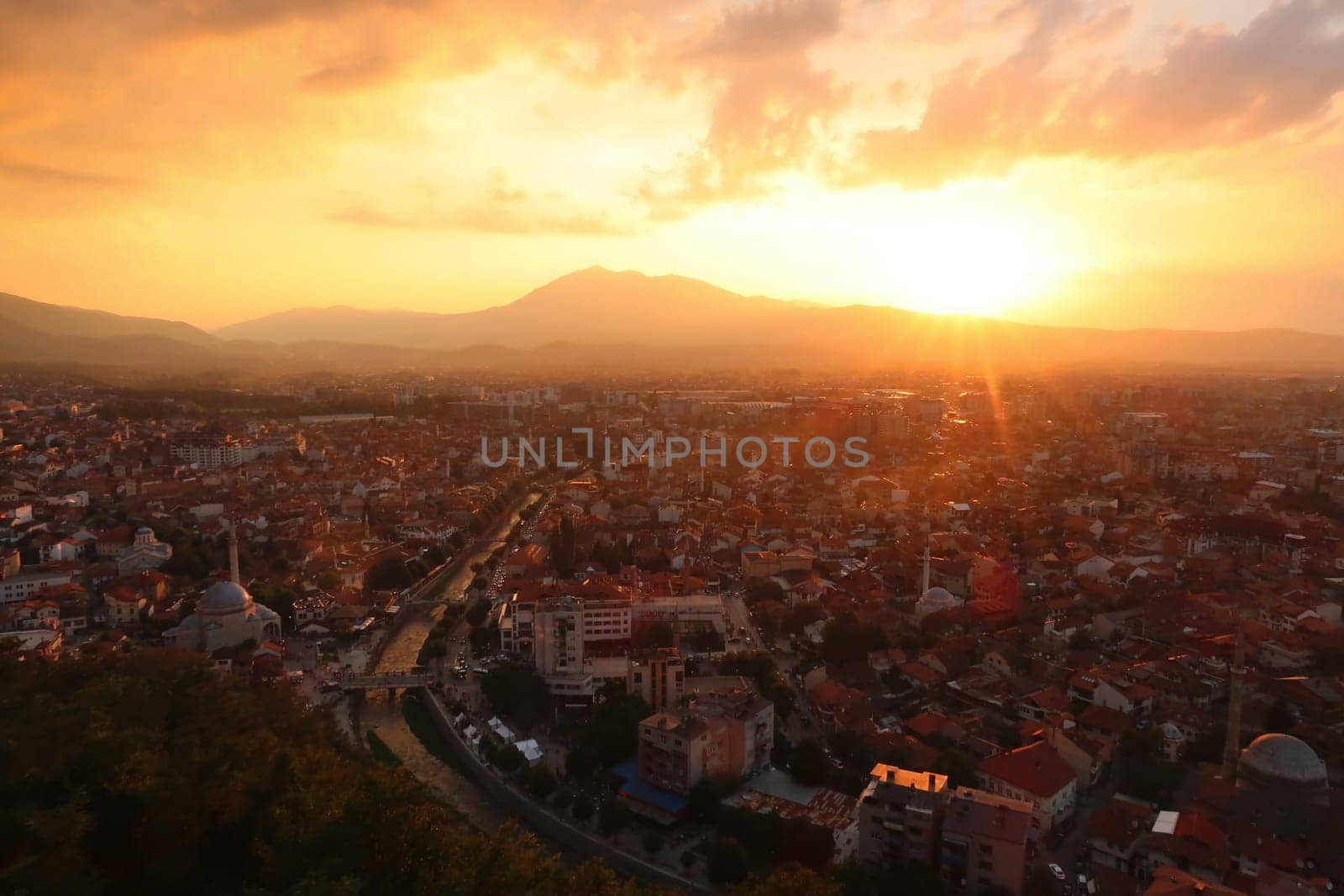 View from the Prizren Fortress onto the old town of Prizren, covered in golden sunlight during sunset, Prizren, Kosovo 2022