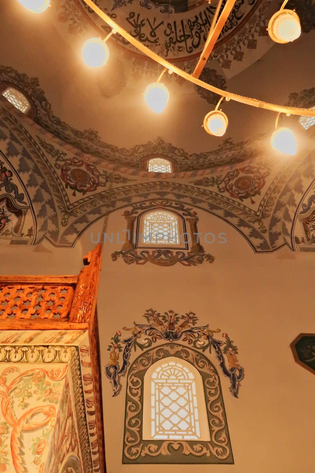 Elaborate ceiling and wall painting, fresco, decoration, pattern, ornament next to the golden chandelier inside the Sinan Pasha Mosque, an ottoman mosque in the old town of Prizren, Kosovo 2022