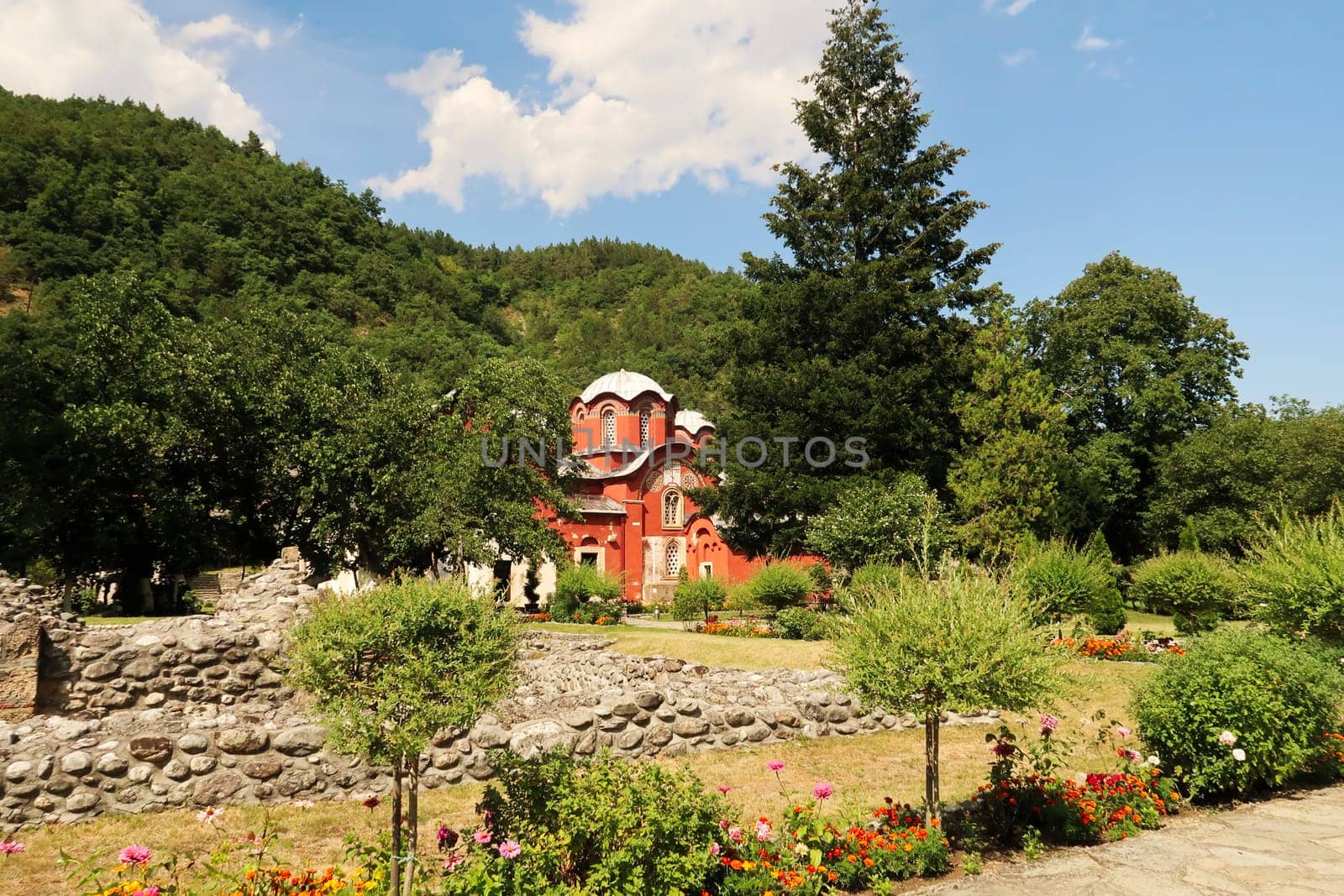 Inside the courtyard, garden of the Patriarchate of Pec Monastery, view between the trees onto the Church Complex, outside Peja, Kosovo 2022