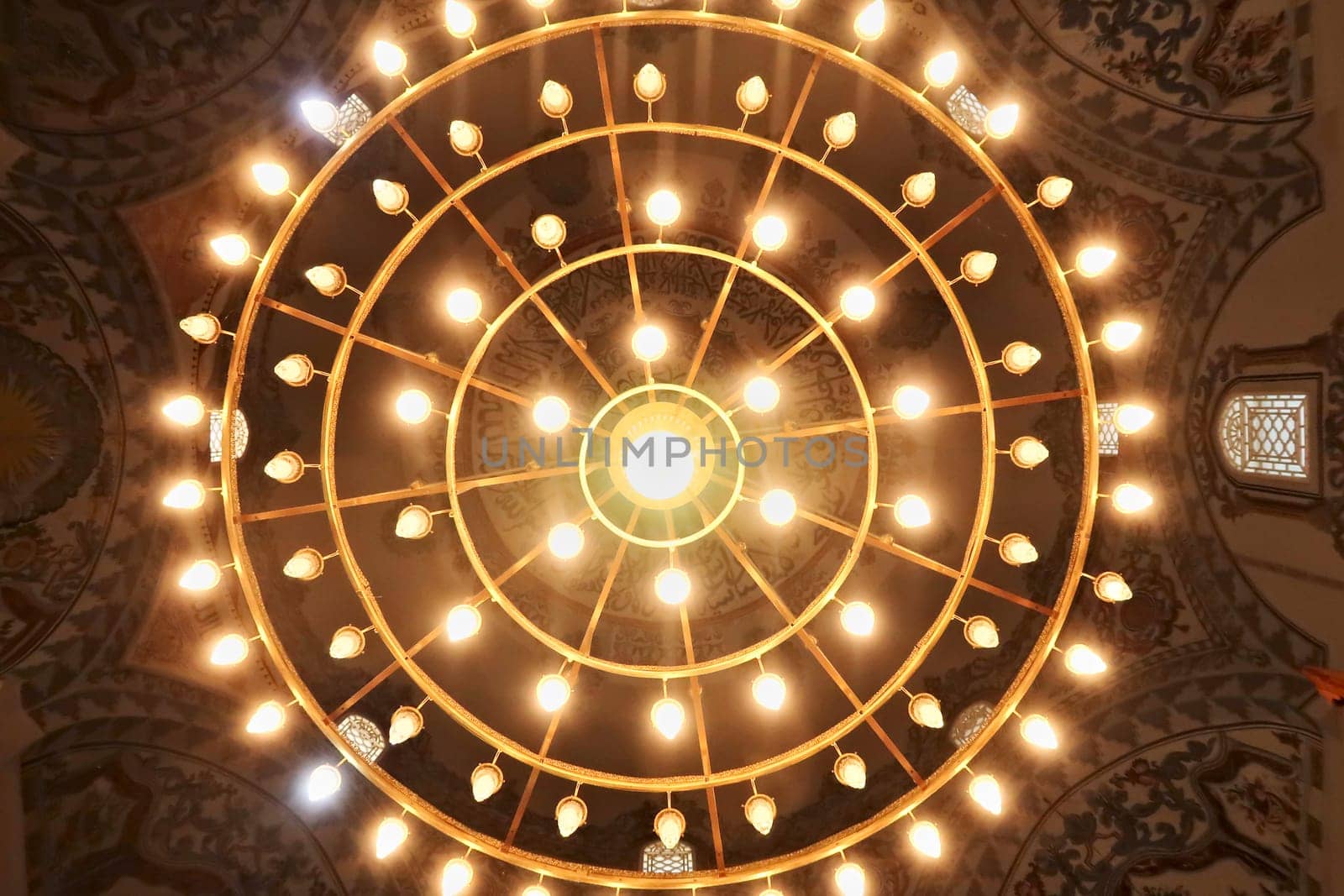 Looking up to the majestic chandelier hanging from the ceiling with elaborate painting, fresco, pattern decoration inside the Sinan Pasha Mosque, an ottoman mosque in the old town of Prizren, Kosovo 2022