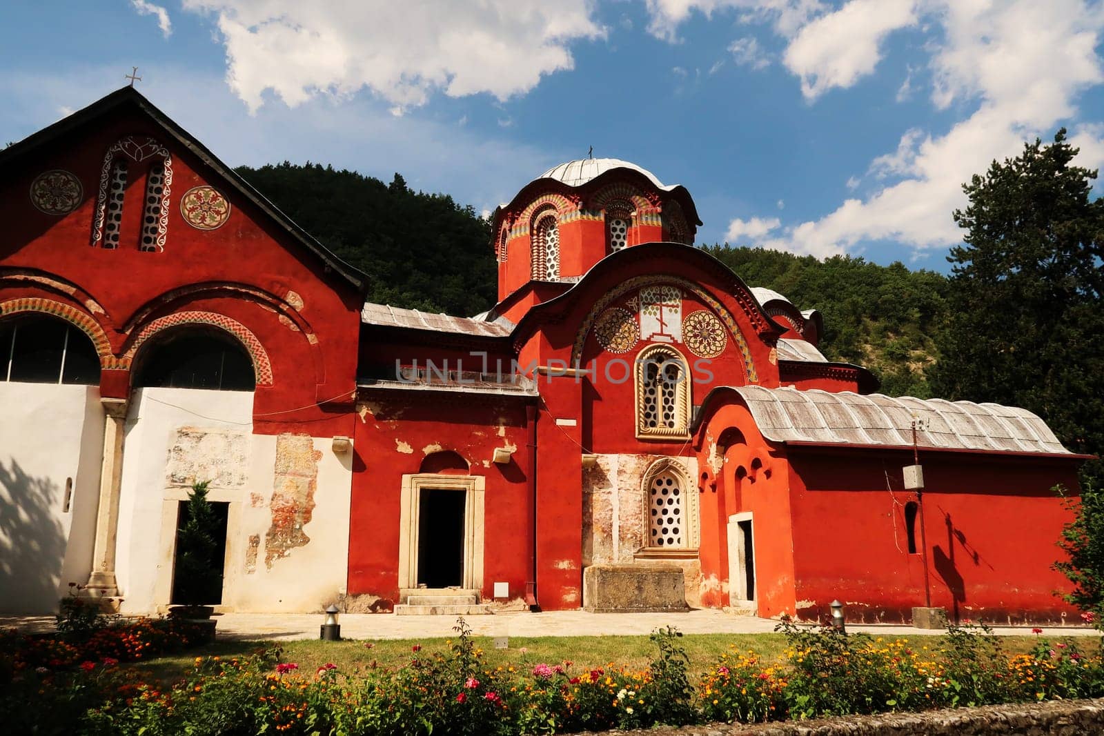 The bright red Church Complex inside the courtyard, garden of the Patriarchate of Pec Monastery, outside of Peja, Kosovo 2022
