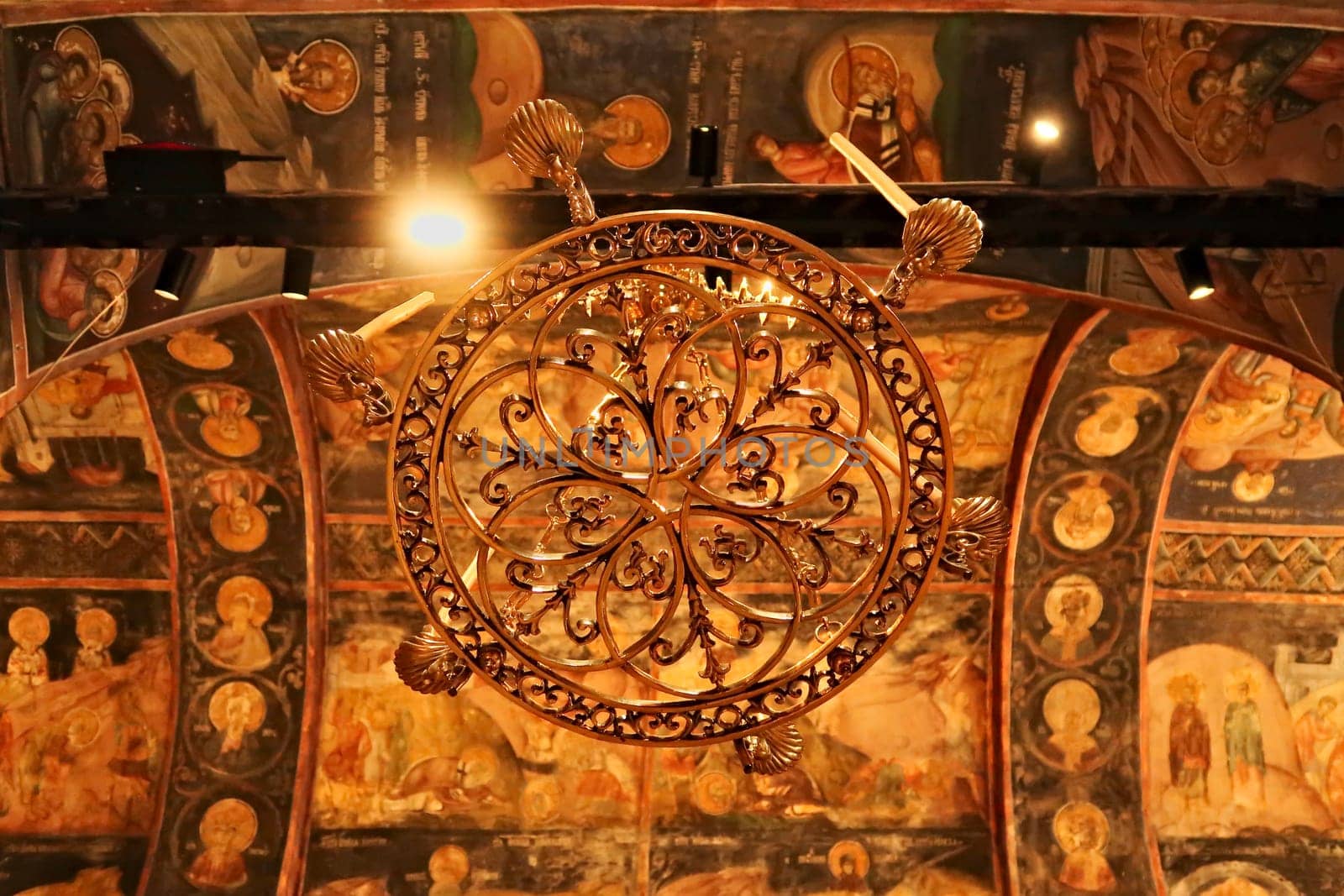 Chandelier inside the Church Complex of the Patriarchate of Pec Monastery, ceiling in the background is completely covered in colorful paintings, frescos, outside of Peja, Kosovo 2022