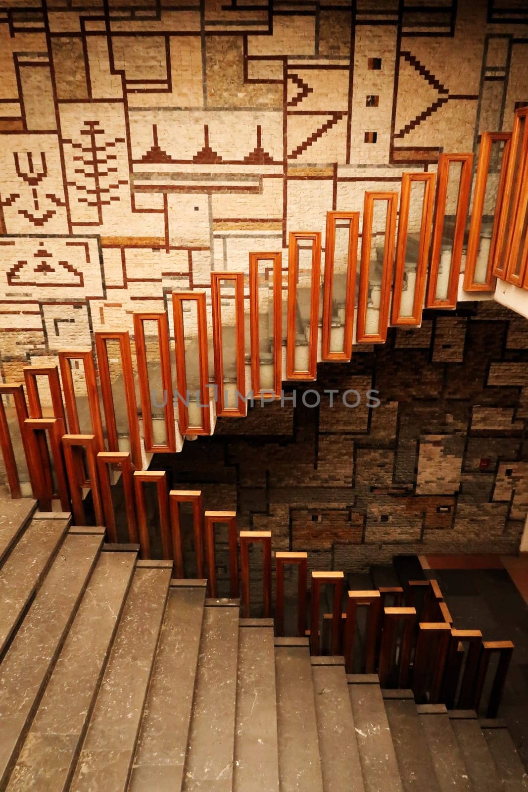 The stairs, staircase, hallway with wooden rails, handrails, railings in front of a patterned wall inside the National University Library of Kosovo, Prishtina, Pristina, Kosovo, 25th of July 2022