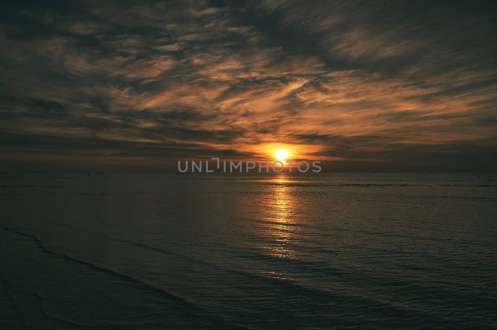 Sunset on the beach by the sea. Gentle waves. Sparkling water. The island of Poel on the Baltic Sea. Nature photo from the coast