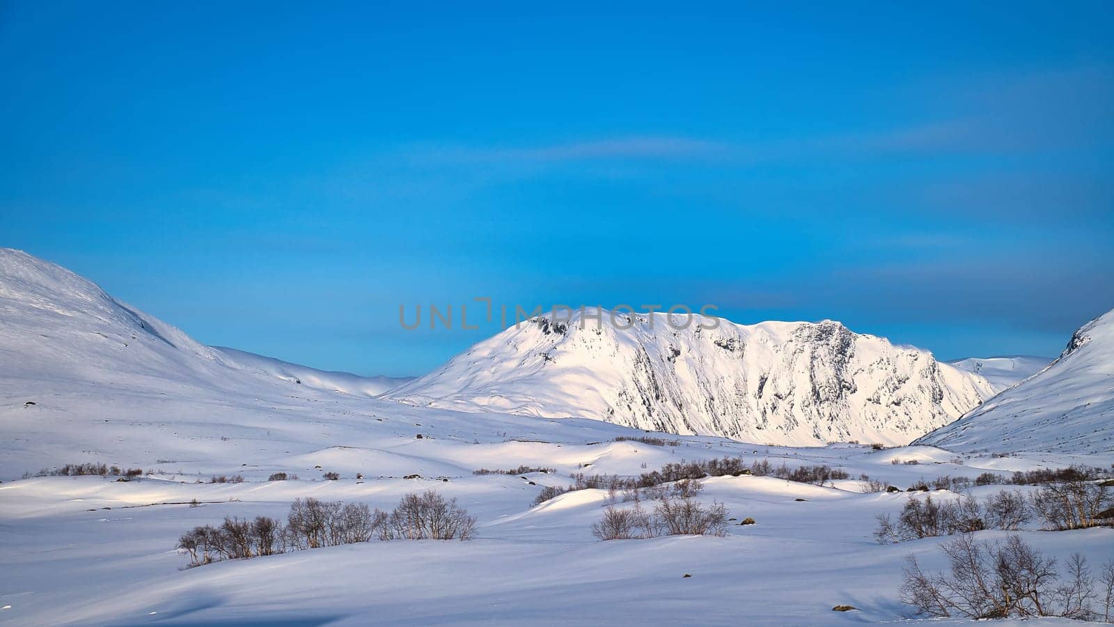 Norwegian high mountains in the snow. Mountains covered with snow. Snow-covered landscape in Scandinavia