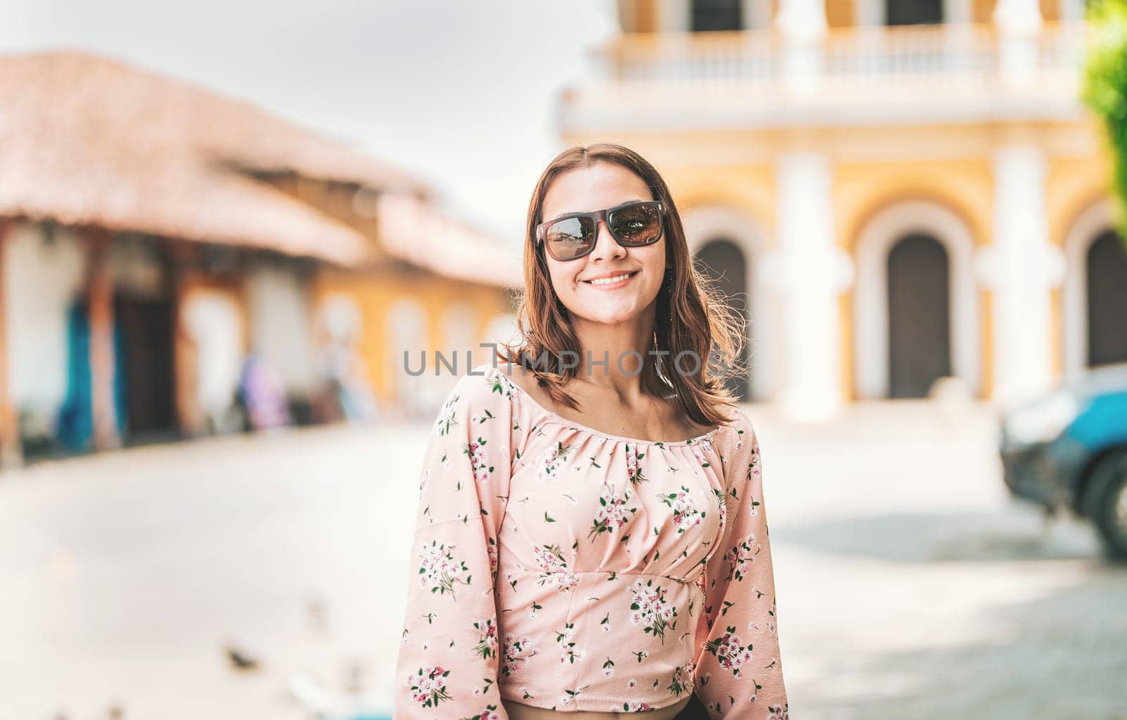Portrait of beautiful tourist girl in a tourist square. Granada, Nicaragua. Portrait of smiling woman traveler in a tourist square