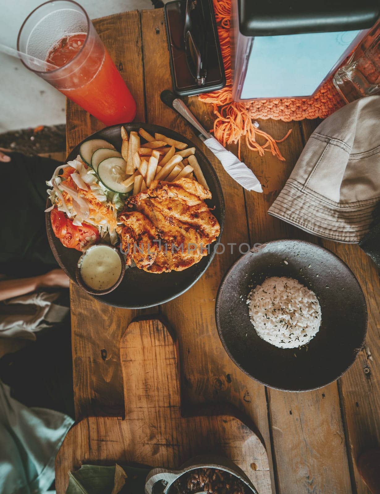 Top view of traditional roast chicken with french fries and salad served on wooden table