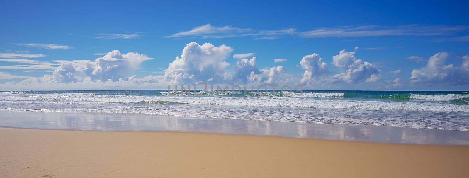 Panoramic view of Sky Clouds Surf and Sand Background on a sunny day at the beach