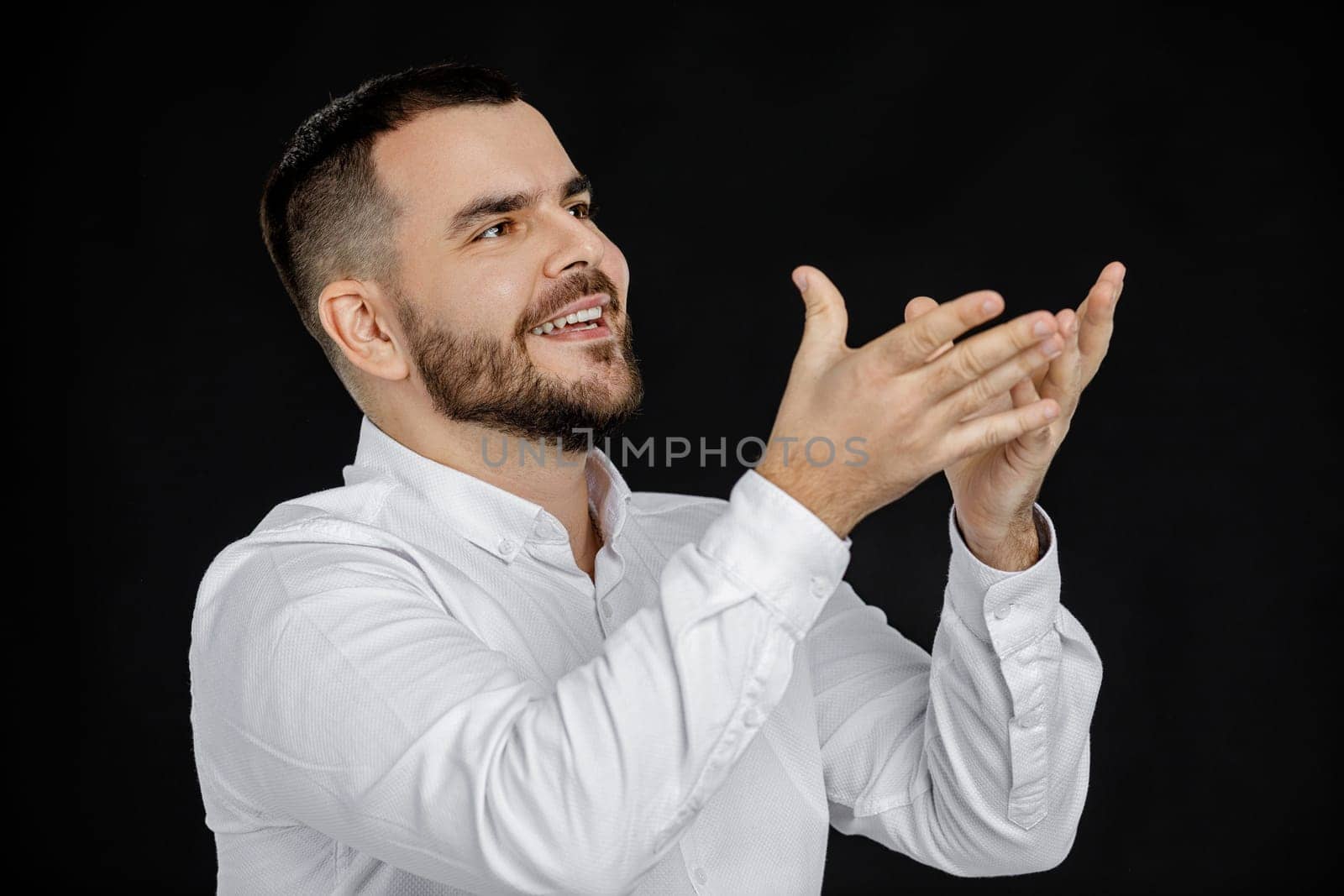 portrait of bearded man in white shirt telling something isolated on black background. man explains to someone