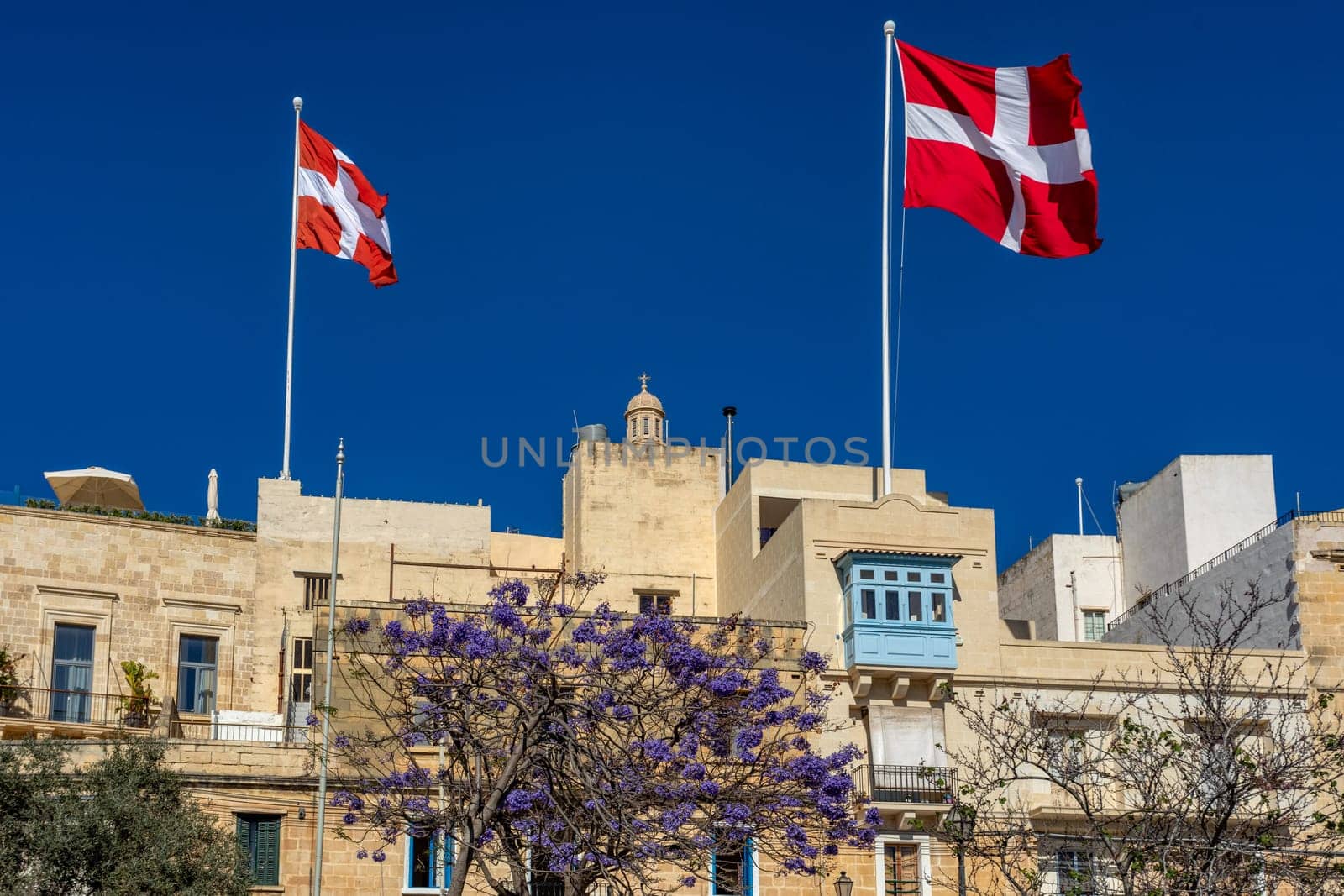 Medieval Malta: Birgu's skyline features iconic historic Birgu buildings decorated with Maltese flags. Cultural heritage of Malta