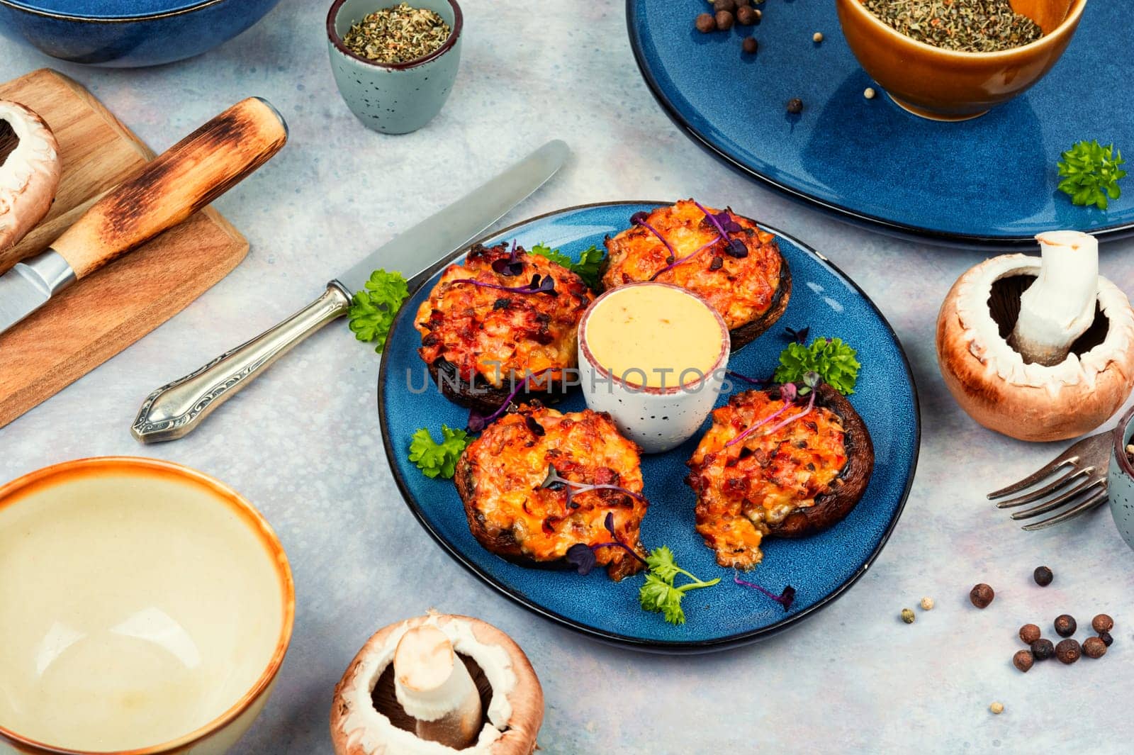 Stuffed mushrooms, champignon mushroom caps filled with vegetables on rustic wooden table. Healthy food