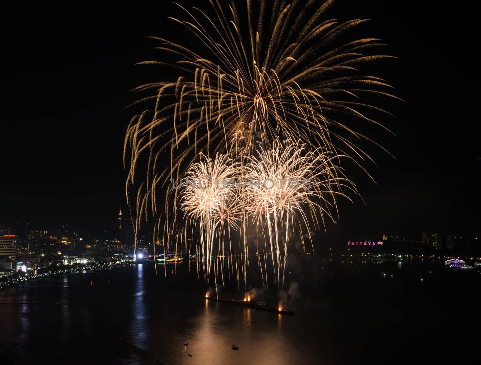 Big yellow firework on the sky at Pattaya coast with cityscape background, Thailand