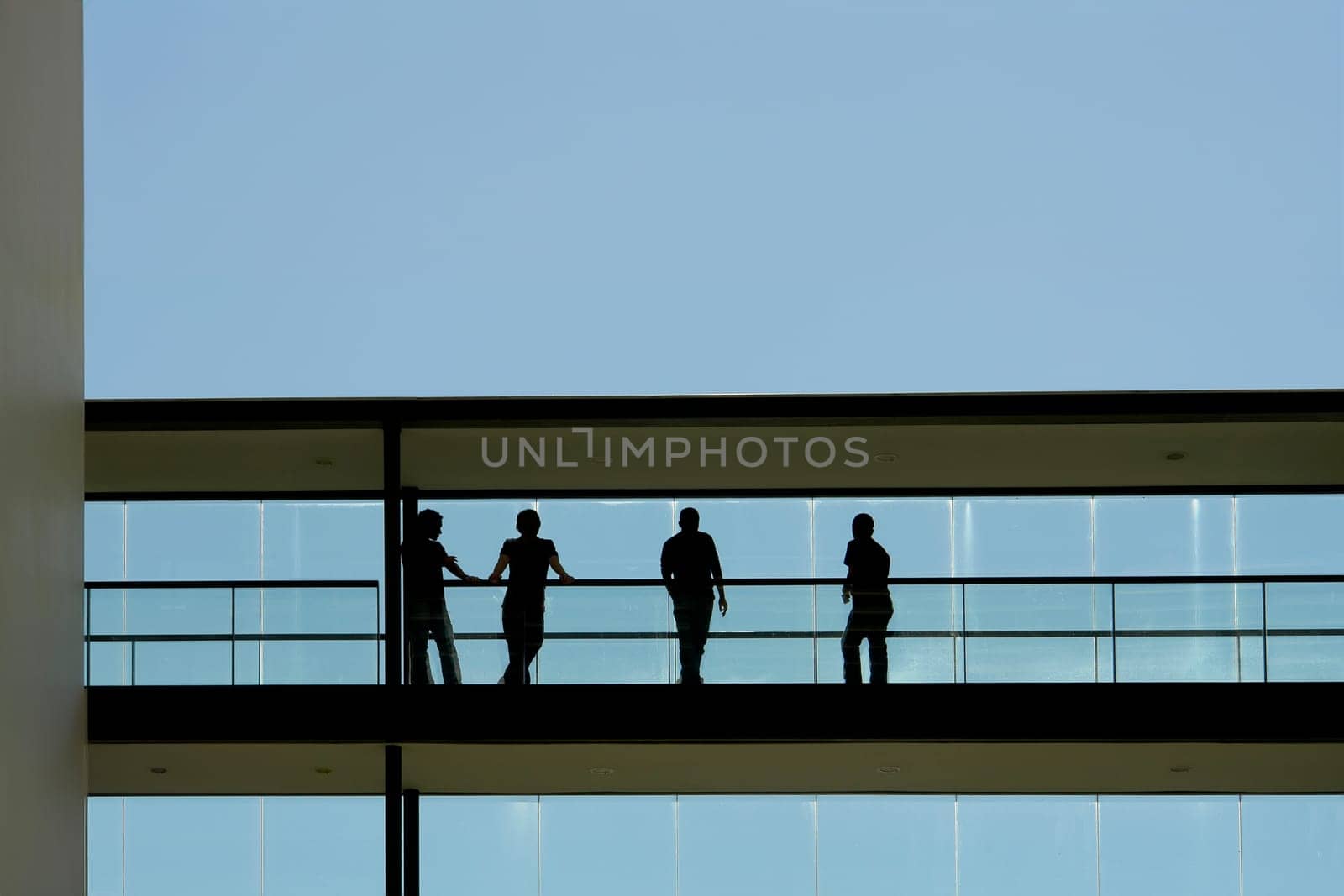 people in silhouette at a modern building