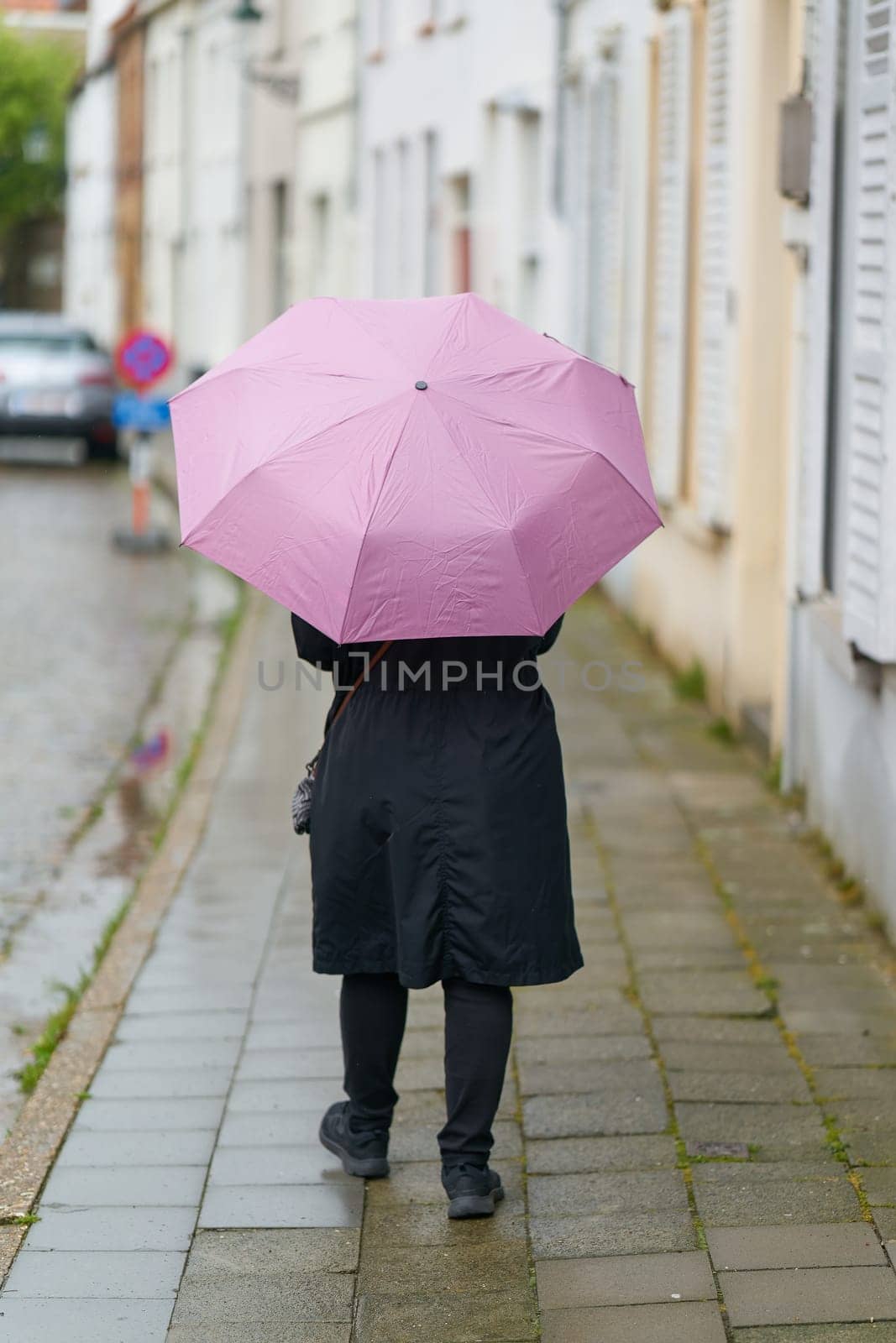 Woman with umbrella in rainy weather in the old town of Bruges in Belgium