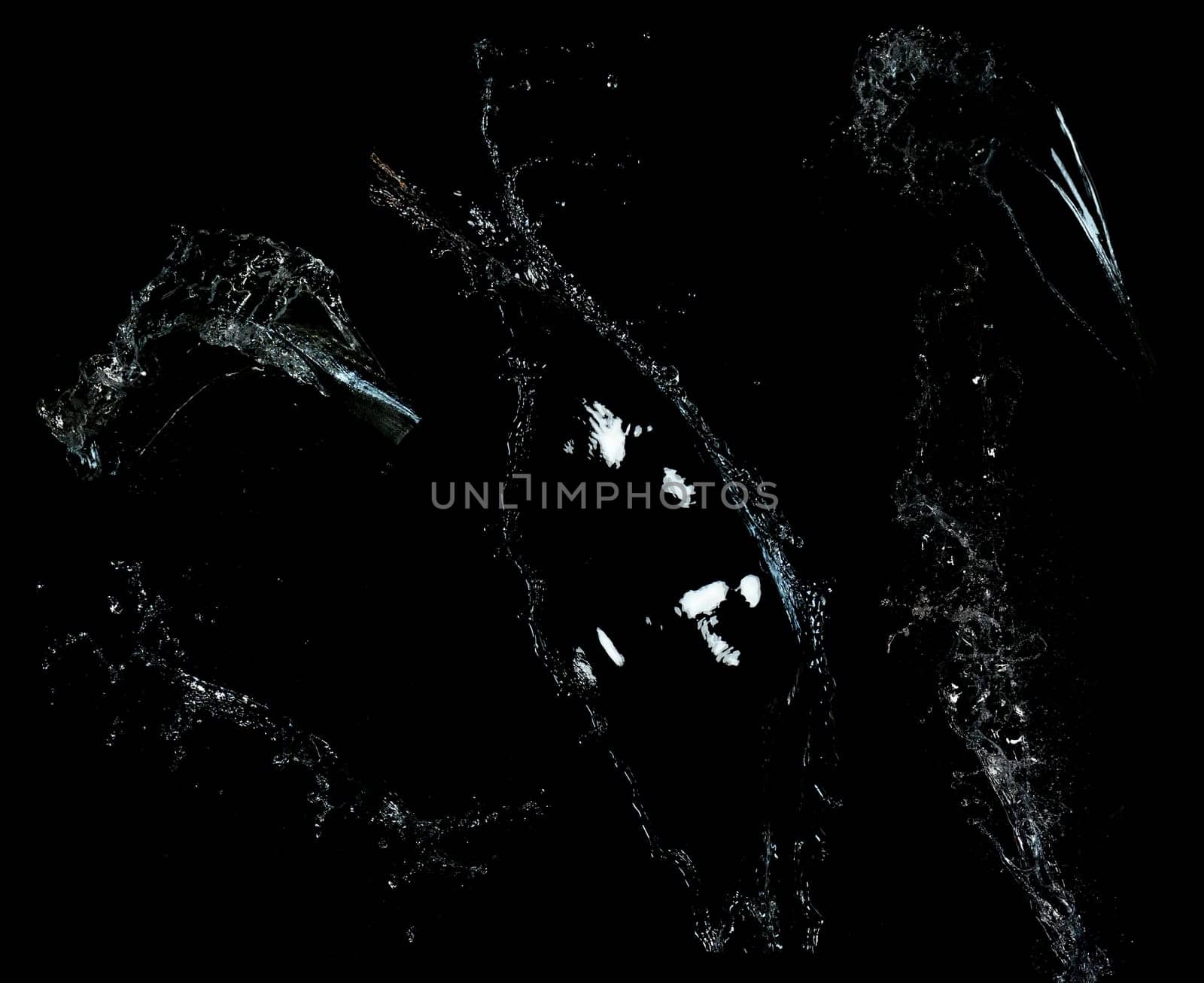 Long stream of fresh transparent water isolated on black background. Splash and drops