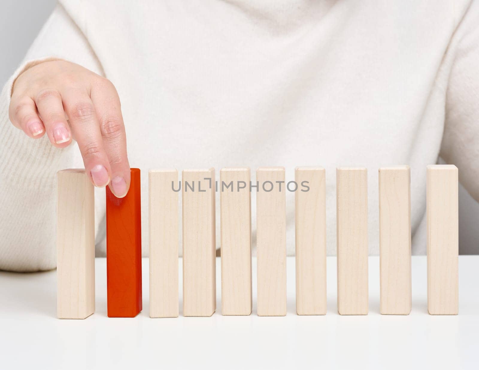 Wooden blocks on the table, a woman's hand holds one. The concept of finding unique, talented employees