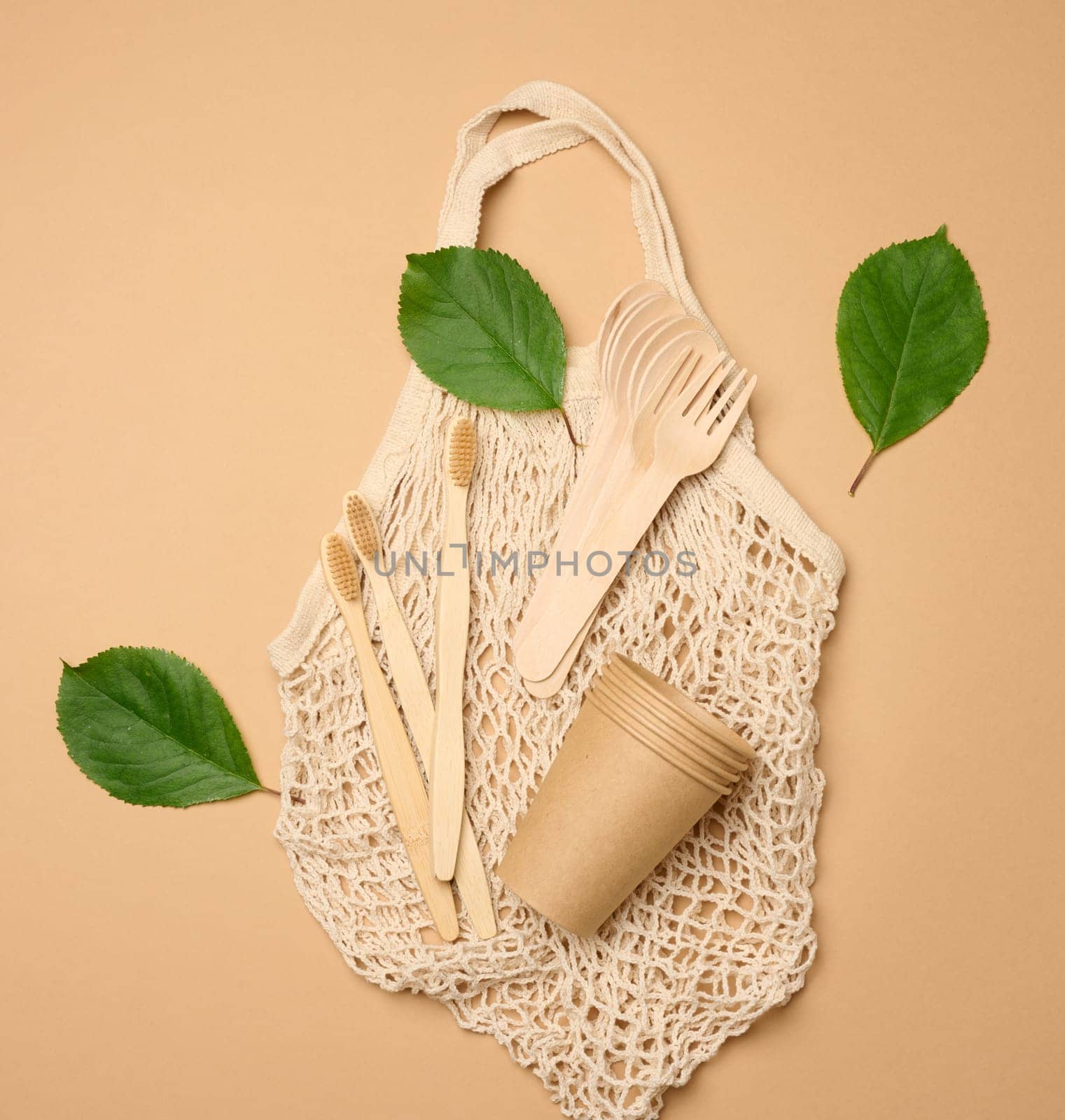 Cotton bag, wooden spoon, cups on a brown background. Waste recycling concept, zero waste