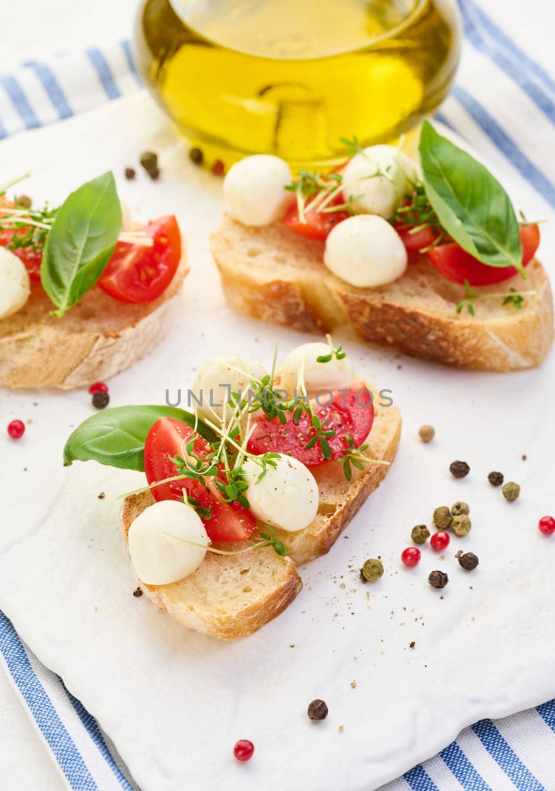 Round mozzarella, cherry tomatoes and microgreens on a piece of white bread, a healthy sandwich, top view