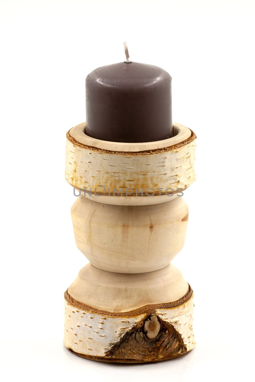 Wooden turned birch candlestick on a white background. Selective focus with shallow depth of field.