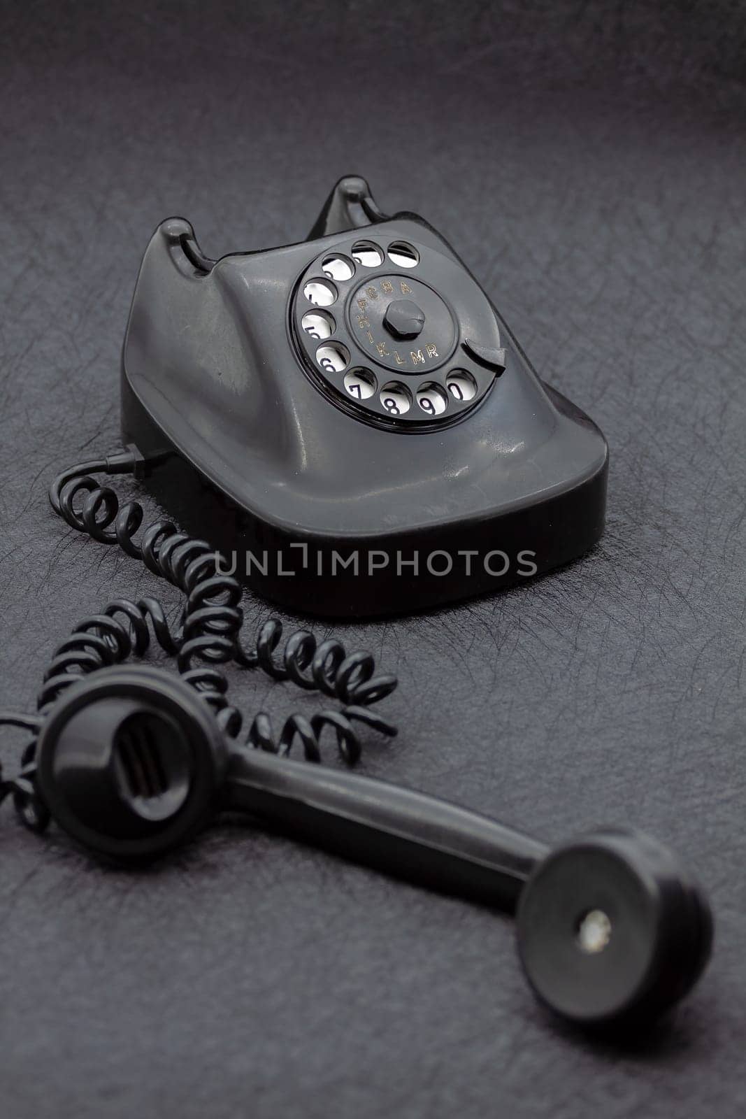 Vintage analog bakelite phone in black color. Selective focus with shallow depth of field.