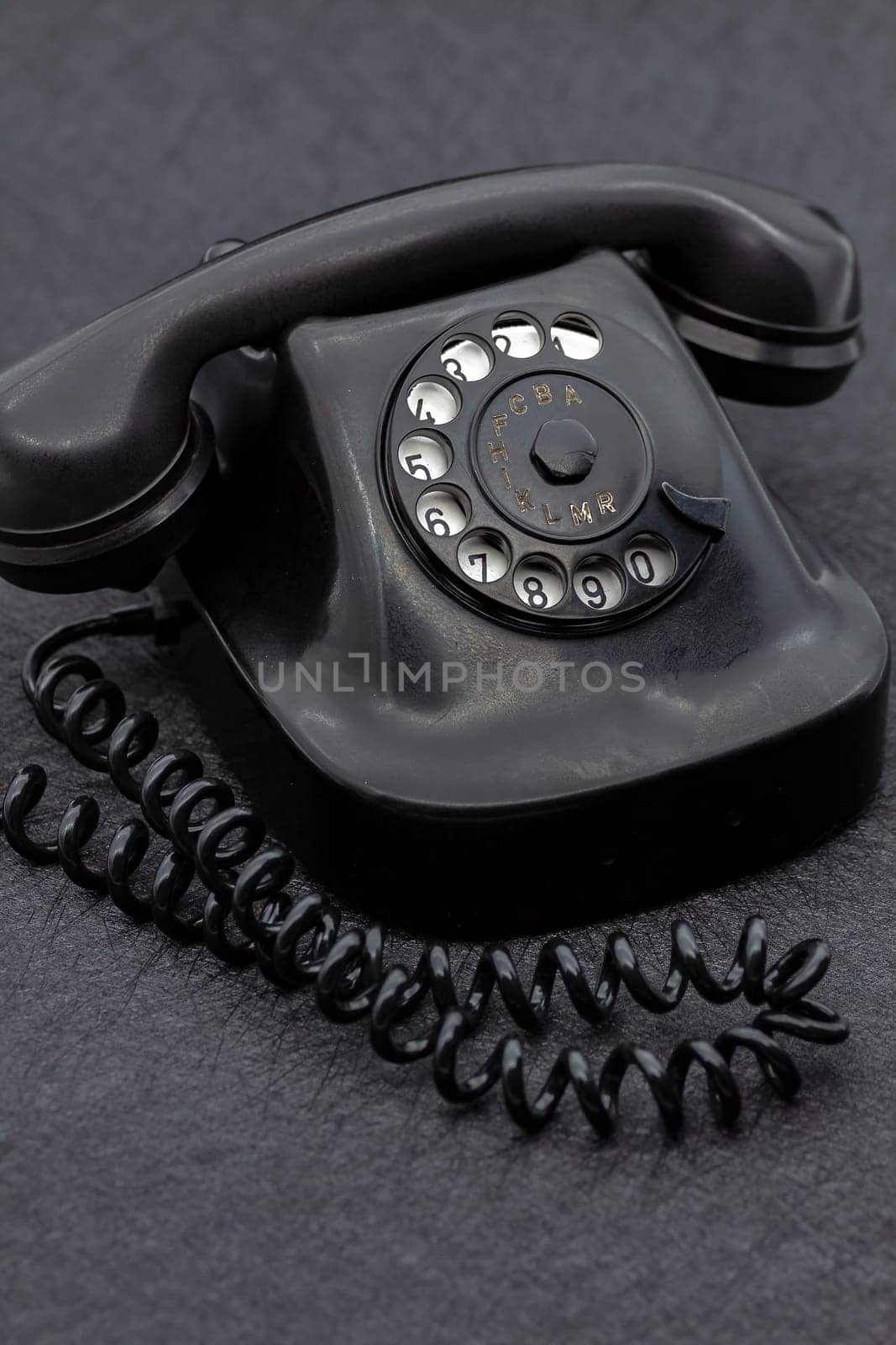 Vintage analog bakelite phone in black color. Selective focus with shallow depth of field.