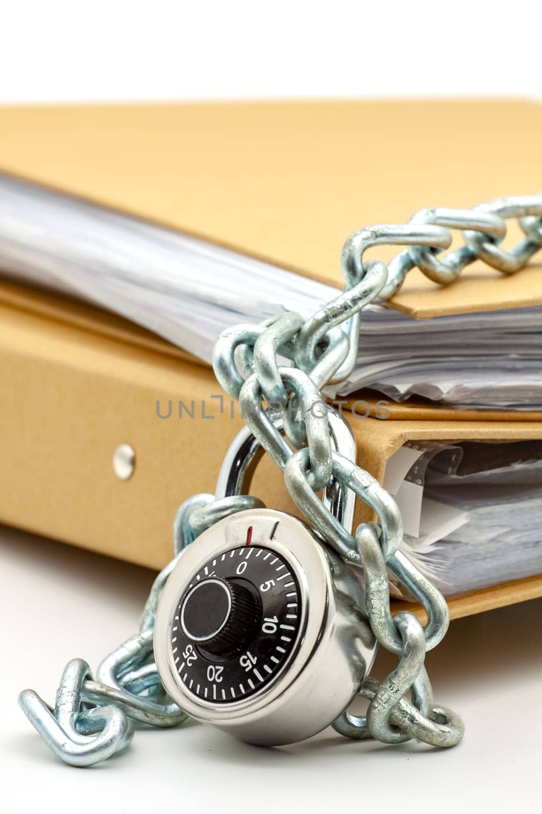 Cardboard document folders locked with chain and padlock. Selective focus with shallow depth of field.