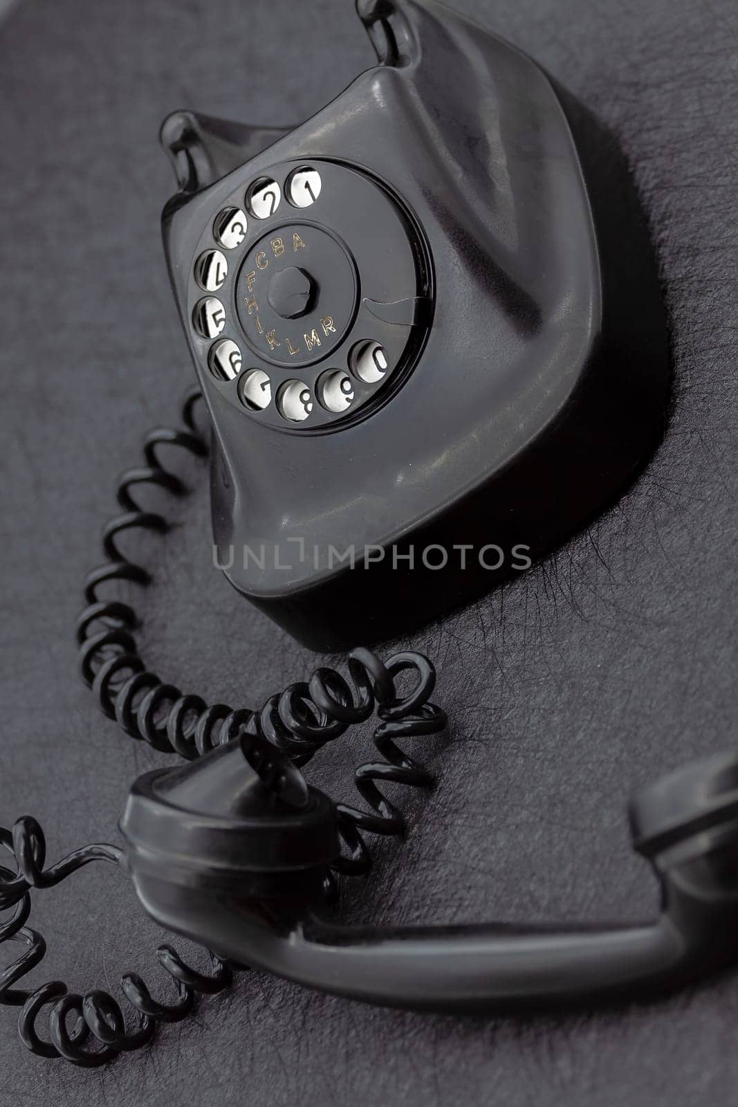 Vintage analog bakelite phone in black color. Selective focus with shallow depth of field.