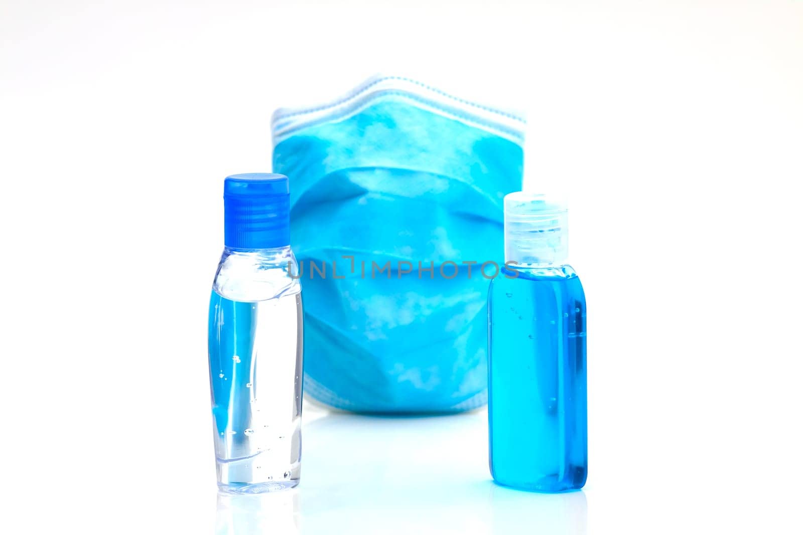 Bottles with antibacterial disinfectant and disposable mask. Selective focus with shallow depth of field.