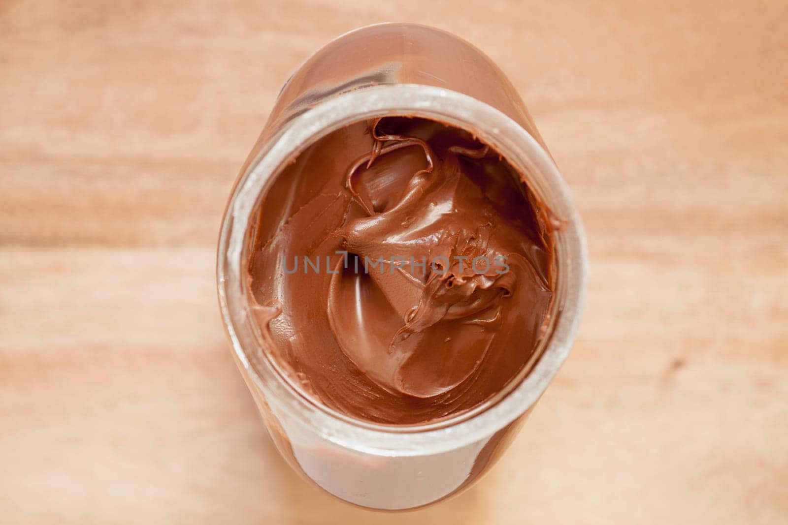 Chocolate spreading cream in glass jar viewed from above.Selective focus with shallow depth of field.