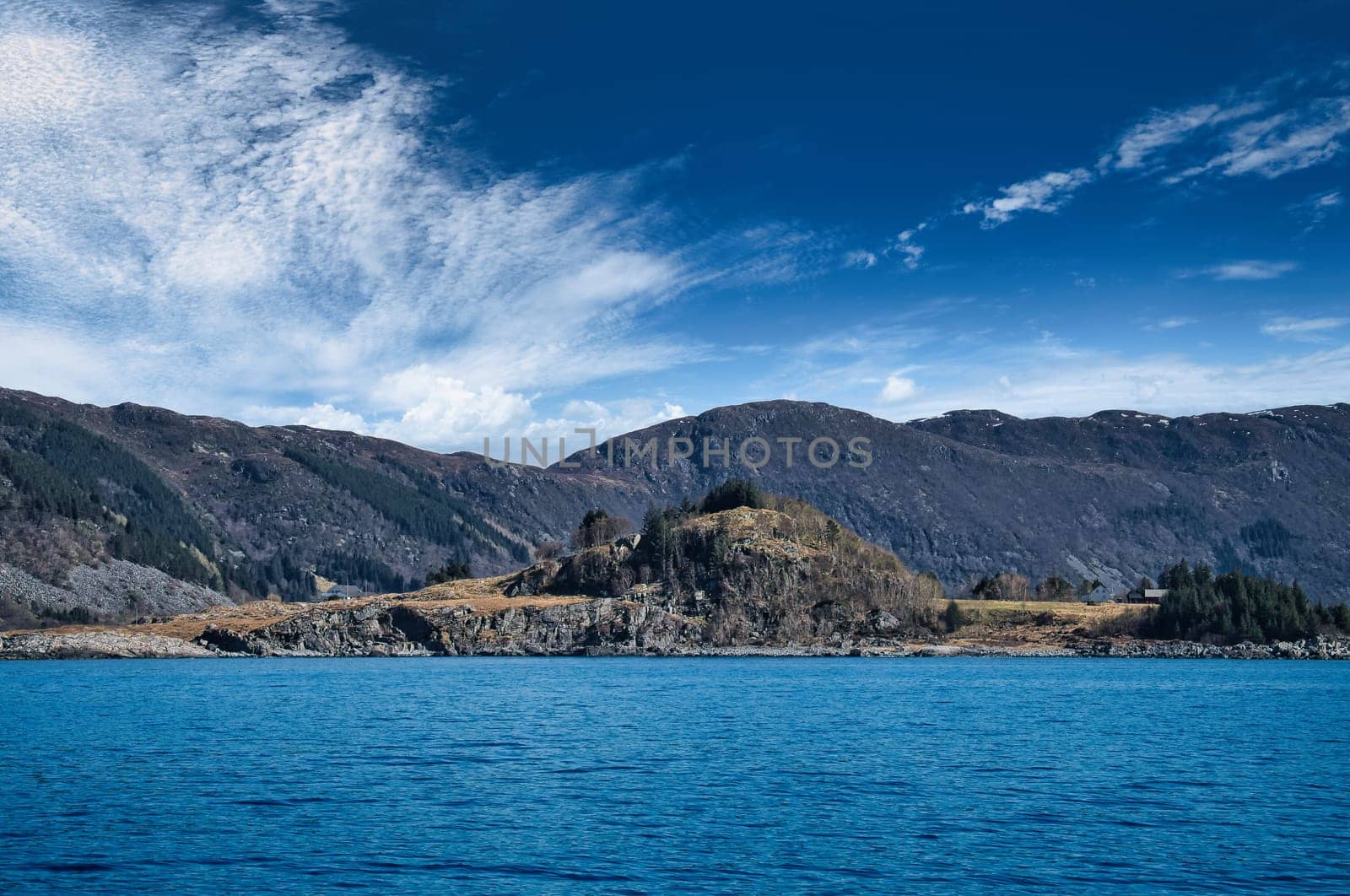 Fjord with mountains on horizon. Water glistens in the sun in Norway. Scandinavia landscape