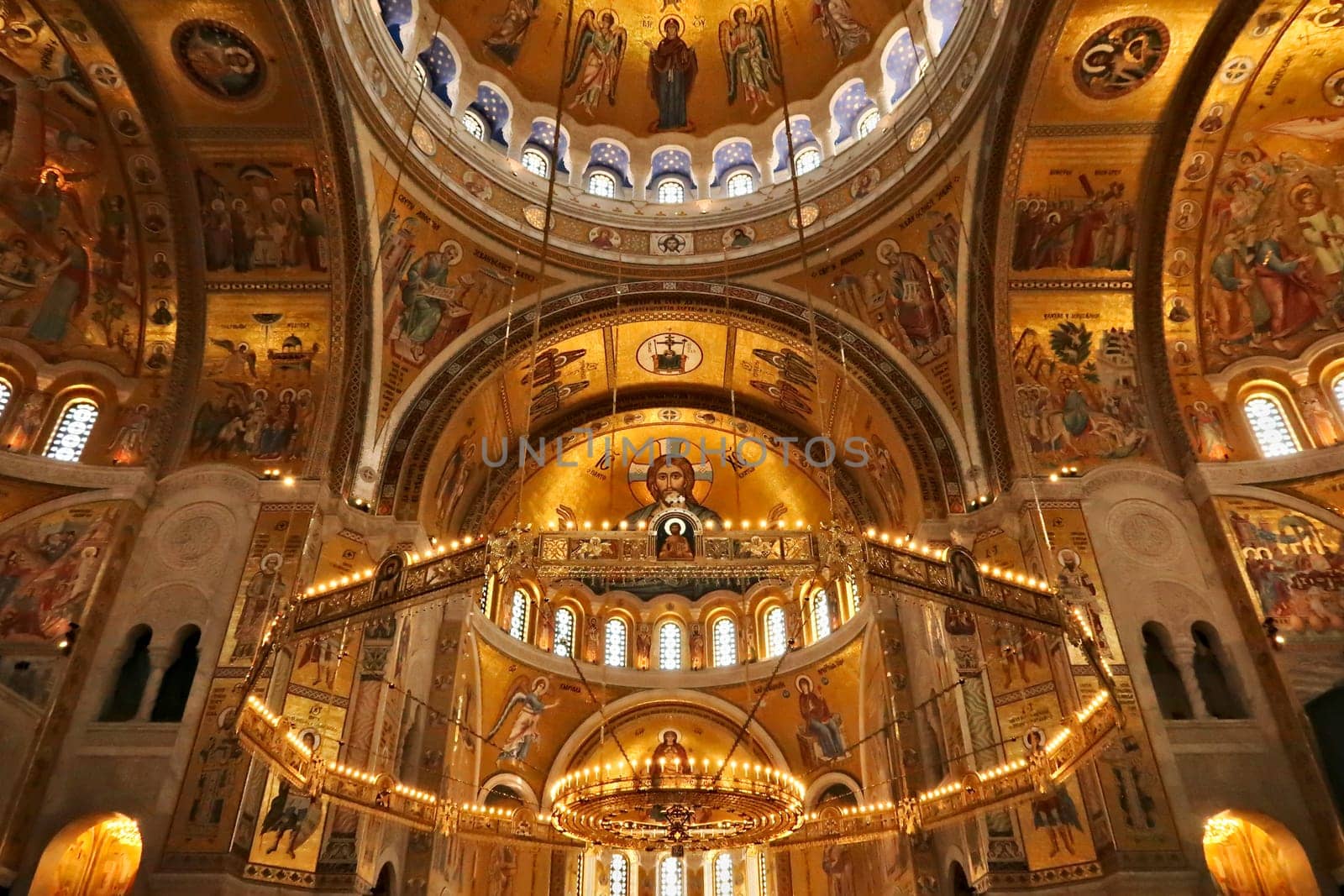 The interior of the Church of Saint, St. Sava, a big golden Chandelier in front of golden walls, vaults, ceiling covered in mosaics, Belgrade, Serbia 2022