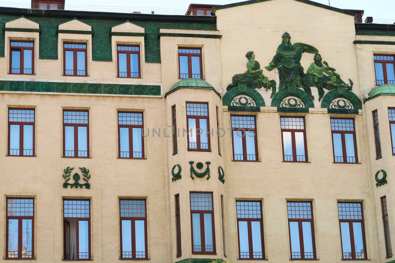 Many windows and the green relief called "Glorification of Russia"", a depiction of the Roman god Neptune on the facade of the Hotel Moskva, Palace Rossiya, an example of Art Nouveau architecture in the city center of Belgrade, Serbia 2022"