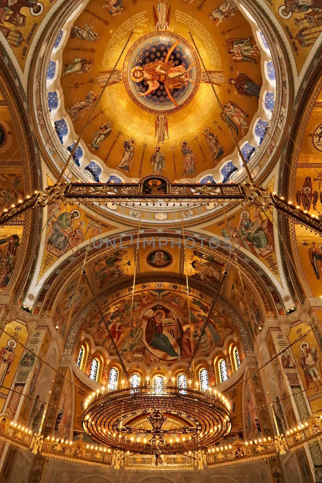 The interior of the Church of Saint, St. Sava, a big golden Chandelier in front of golden walls, vaults, domes, ceiling covered in mosaics, Belgrade, Serbia 2022