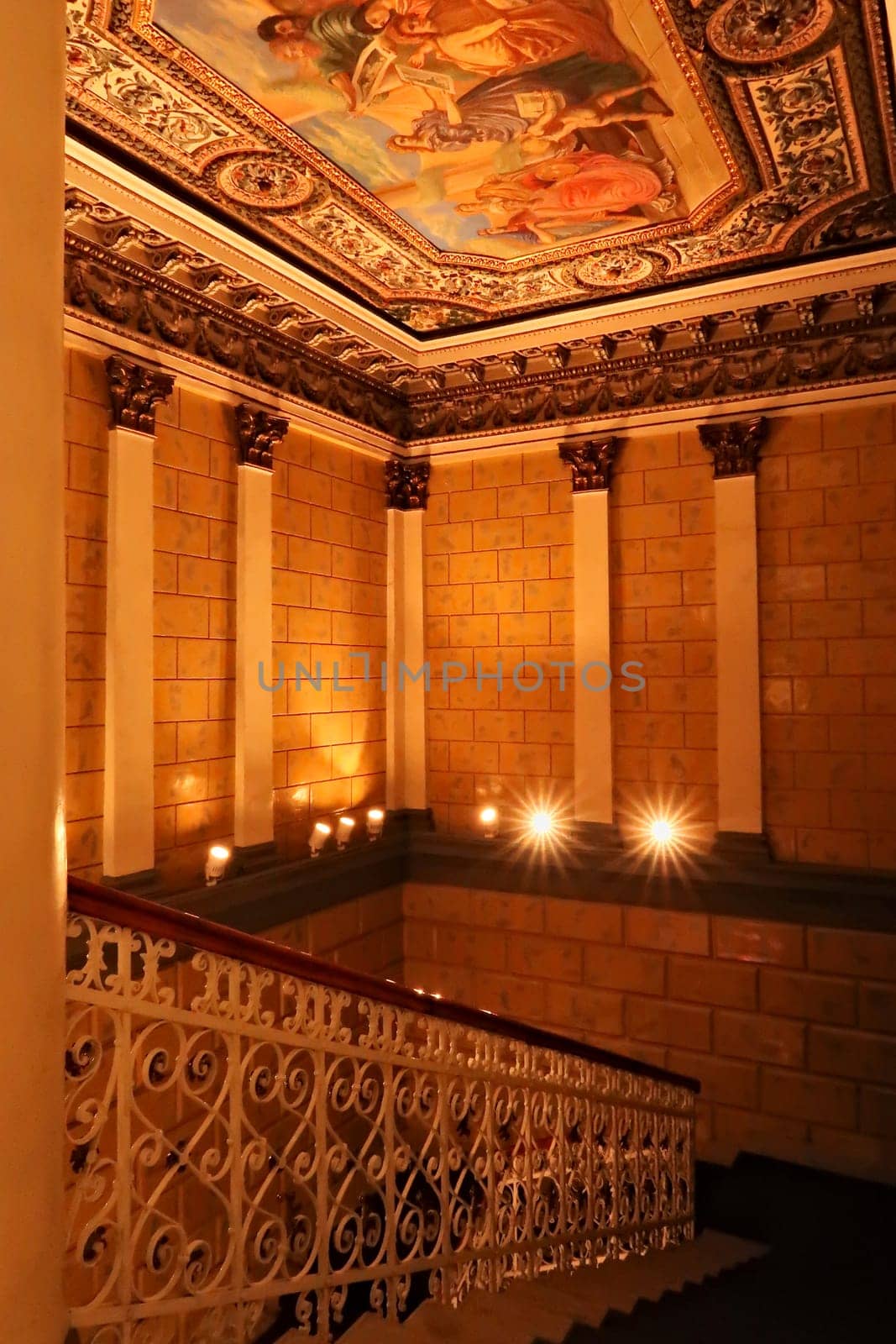 The staircase, stairwell with a colorful ceiling painting and elaborate handrail inside the Dundjerski, Dunderski Palace, a historic building in the old town of Novi Sad, Serbia 2022