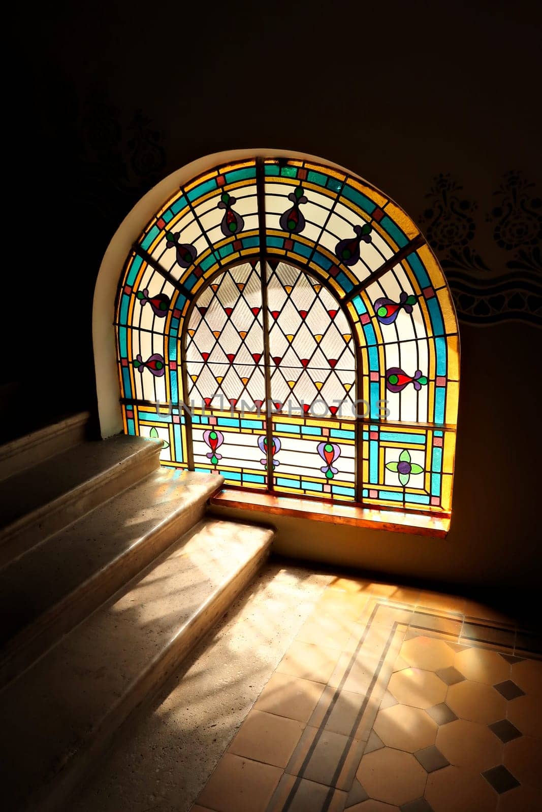 Light ist shining through a stained glass window onto the stairs in the stairwell, stairscase inside the Synagogue of Subotica, Serbia 2022