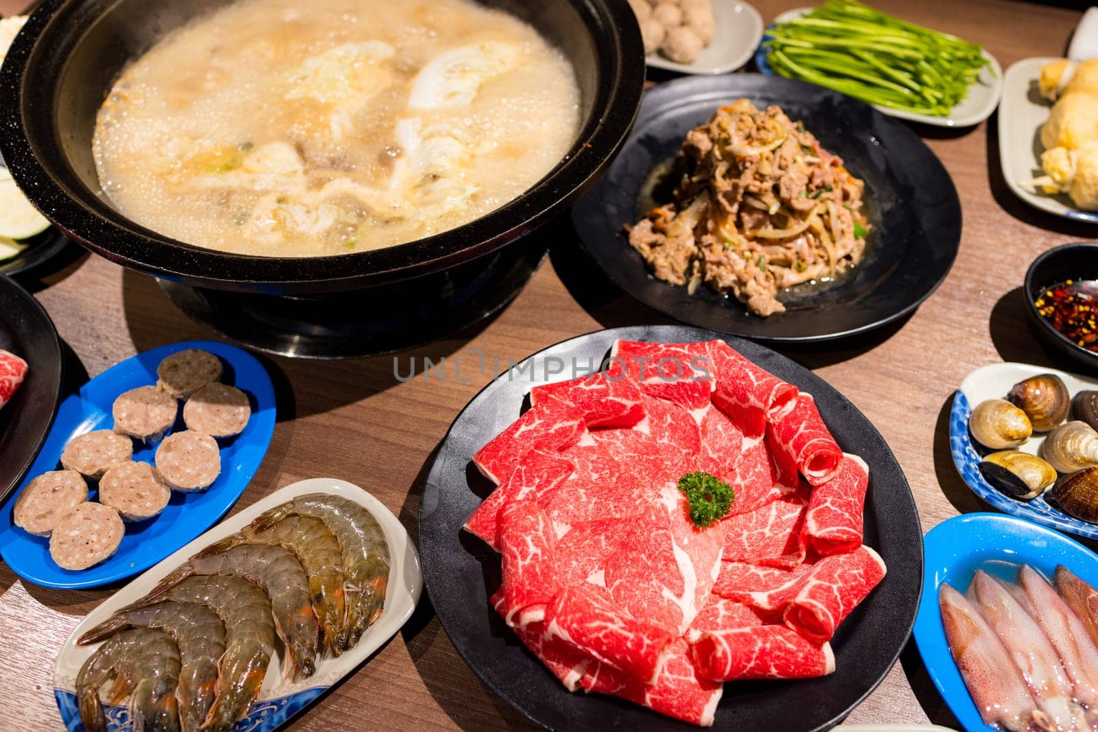 Hot pot with lots of food on the table
