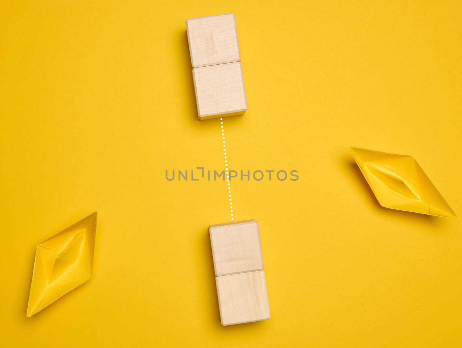 Two yellow paper boats and a barrier between them. Concept of searching for compromises, top view