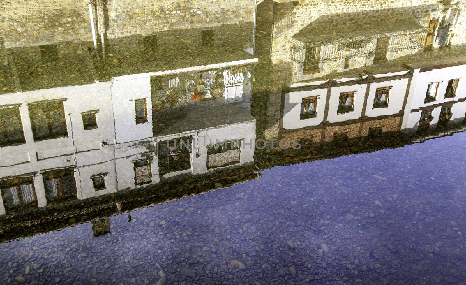 Detail of reflection in the water of a river in an old town