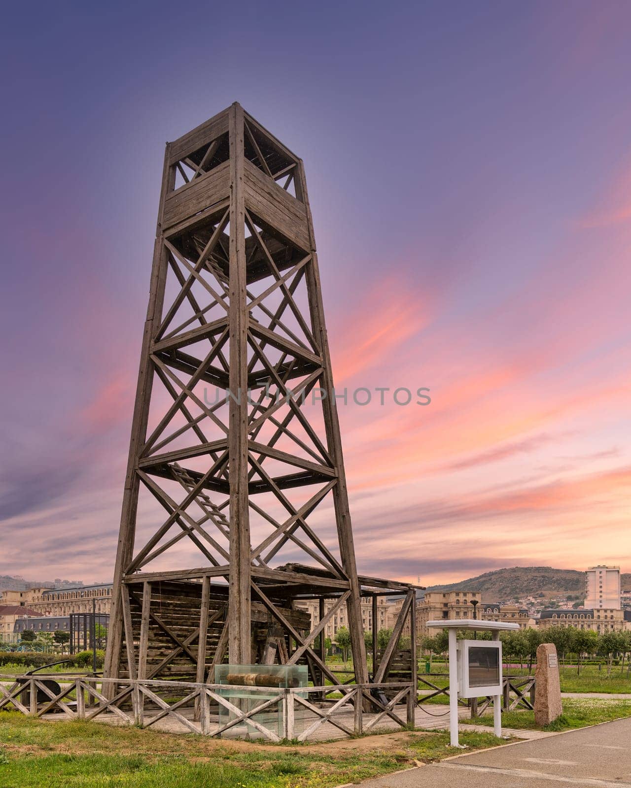 Worlds first industrially drilled oil well in Baku, Azerbaijan. The wooden structure stands tall against a vibrant sunset sky