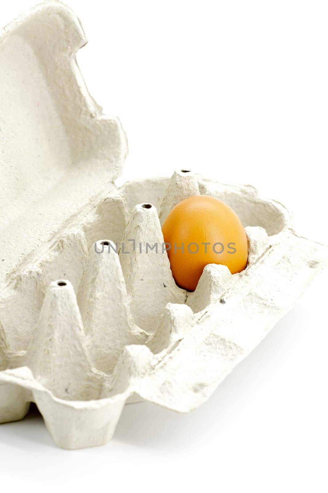 Egg in cardboard box made from recycled paper on a white background