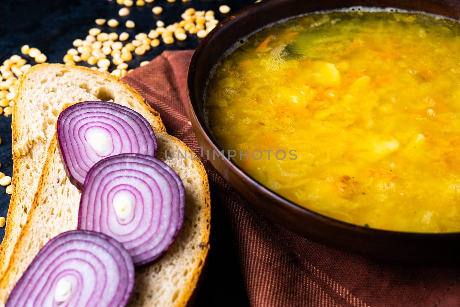 Homemade healthy vegetable soup with some bread and an onion