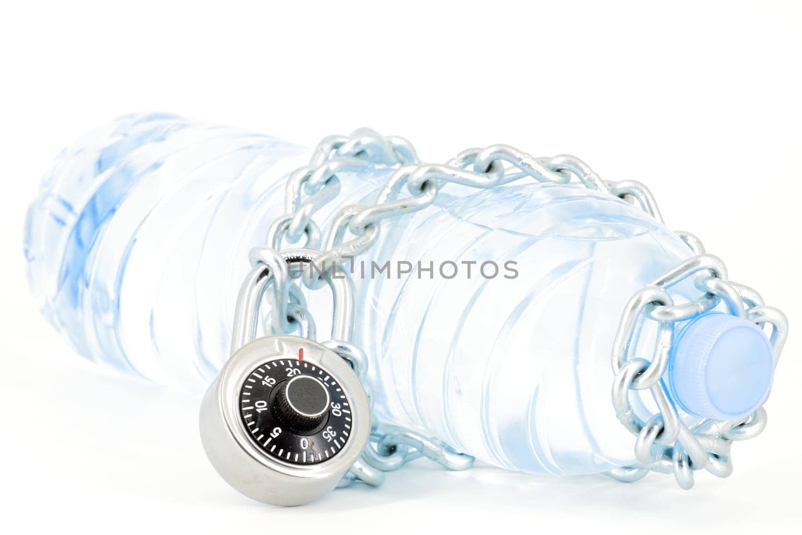 Bottle of mineral water locked with chain and padlock on white background