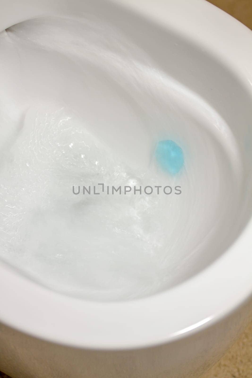 Modern toilet bowl with blue detergent for cleaning and disinfection