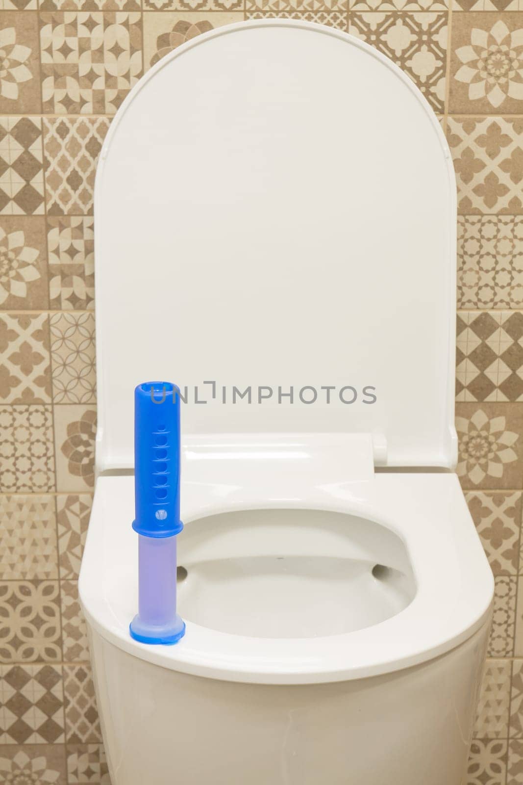 Modern toilet bowl with blue detergent for cleaning and disinfection