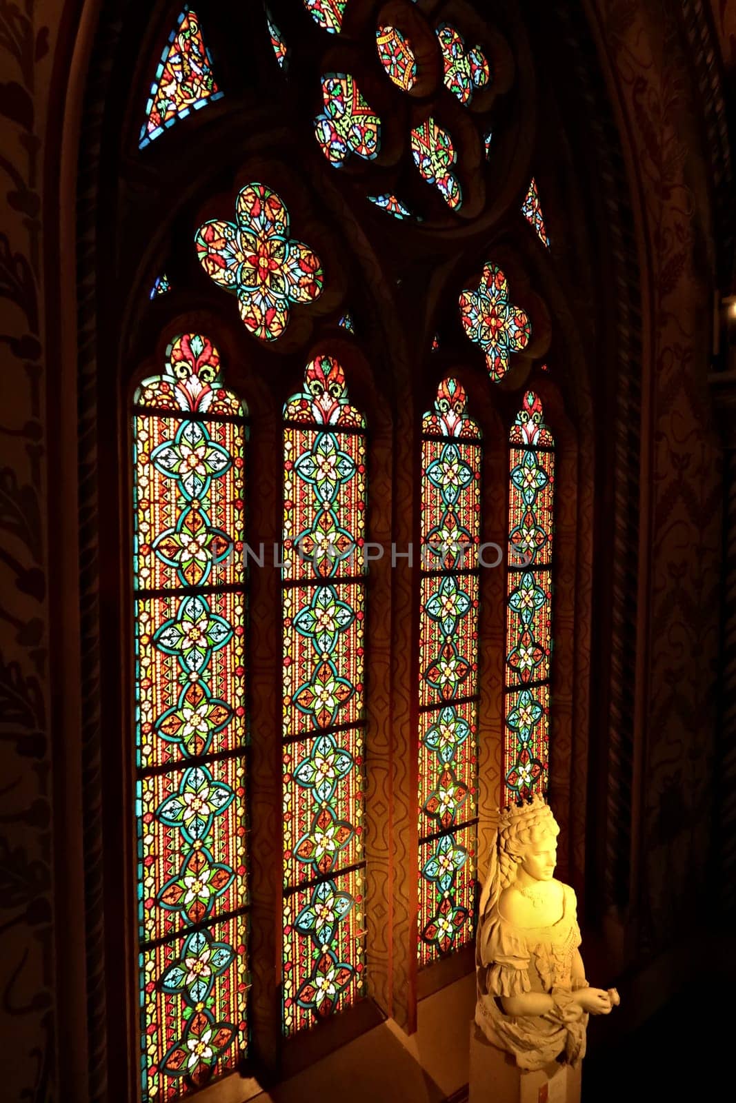 Bust, statue of Empress Elisabeth of Austria, Sissi, Sisi in front of a colorful stained glass window in a gothic shape inside the Matthias Church, Budapest, Hungary 2022