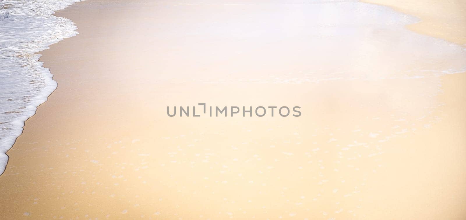 A conceptual sandy beach background with lots of copy space, neutral space for text and AI editing, nobody, no landmarks, just wet sand and white foamy water
